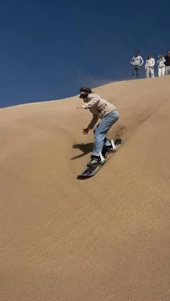 Sandboarding sur les dunes près d'Essaouira