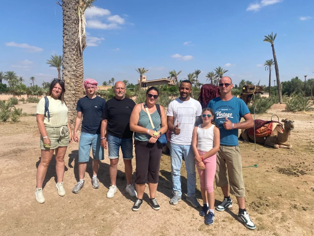 Groupe de visiteurs lors de l'arrêt photo chameau dans la palmeraie